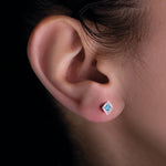 Laden Sie das Bild in den Galerie-Viewer, Titan Ohrstecker mit blauem Topas am Ohr eines Models